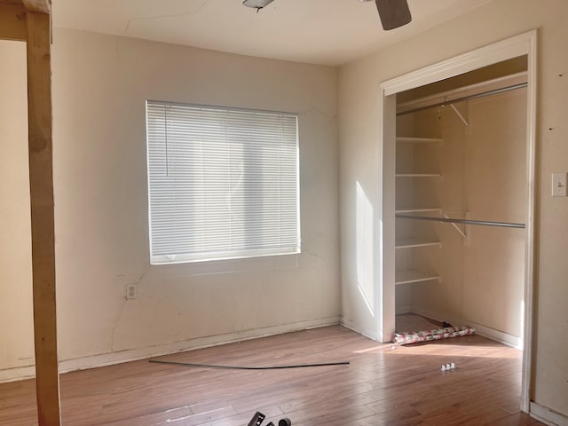 unfurnished bedroom featuring ceiling fan, a closet, and wood finished floors