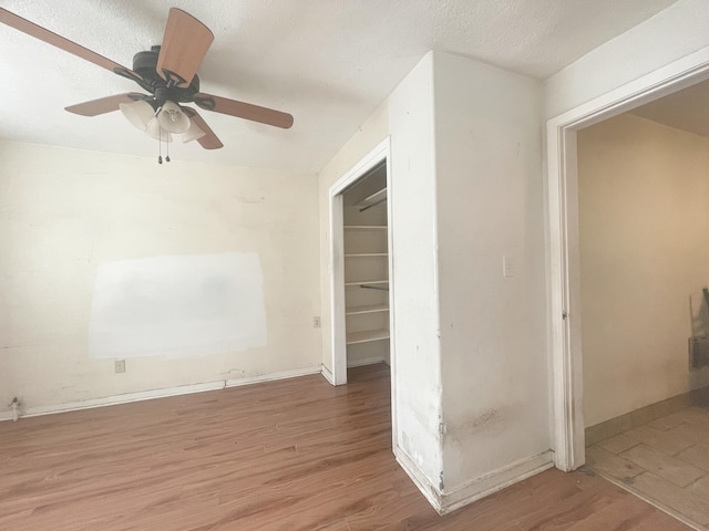 unfurnished room featuring a textured ceiling, wood finished floors, and baseboards