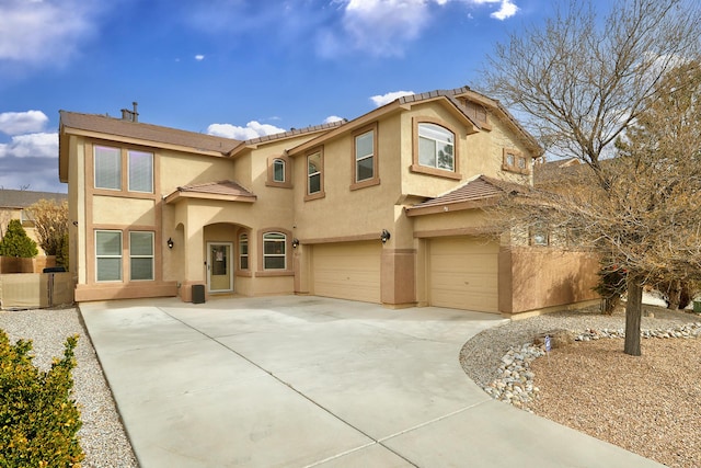 mediterranean / spanish home with a garage, driveway, and stucco siding