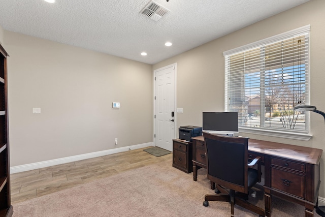 home office with baseboards, visible vents, light colored carpet, a textured ceiling, and recessed lighting