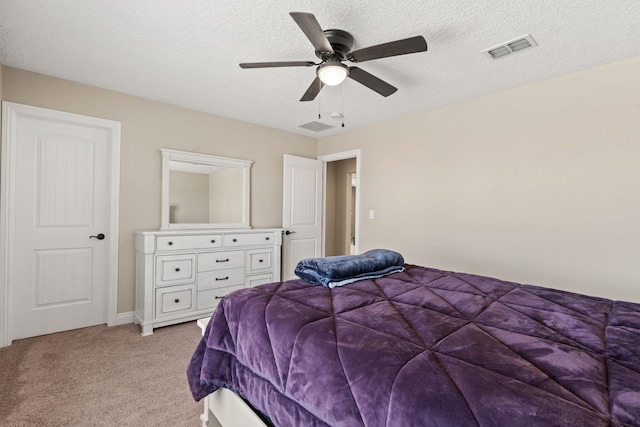 bedroom featuring light carpet, ceiling fan, a textured ceiling, and visible vents