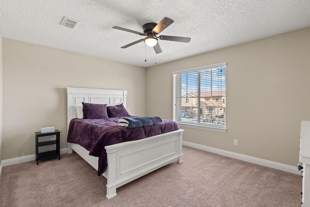 bedroom with a ceiling fan, visible vents, light carpet, and baseboards