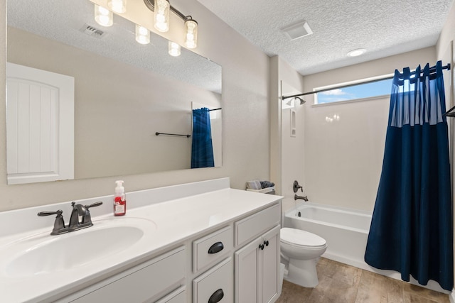 bathroom featuring visible vents, toilet, shower / tub combo, vanity, and a textured ceiling