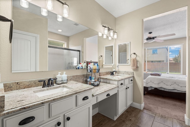 bathroom with ceiling fan, wood finished floors, vanity, baseboards, and a stall shower