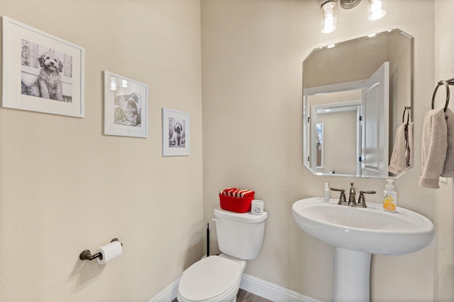 bathroom featuring baseboards and toilet