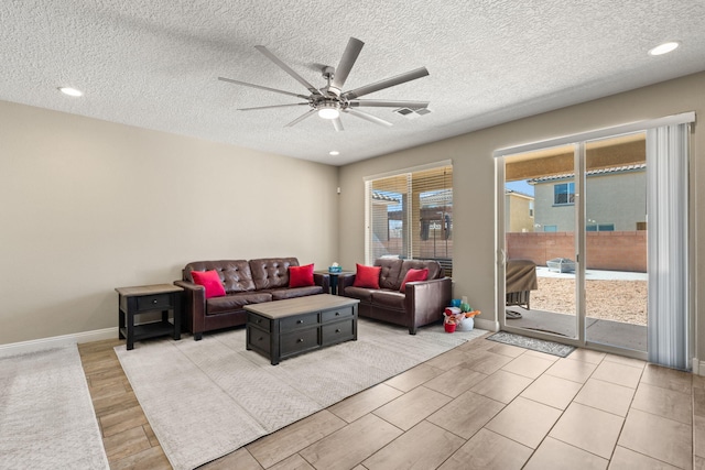 living area featuring visible vents, baseboards, a ceiling fan, a textured ceiling, and recessed lighting