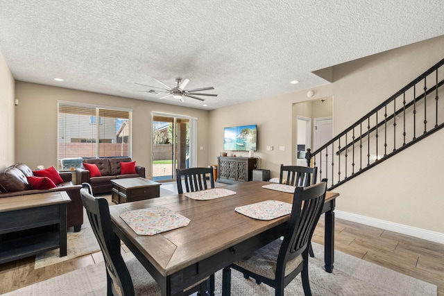 dining space featuring a textured ceiling, recessed lighting, baseboards, stairway, and light wood-type flooring