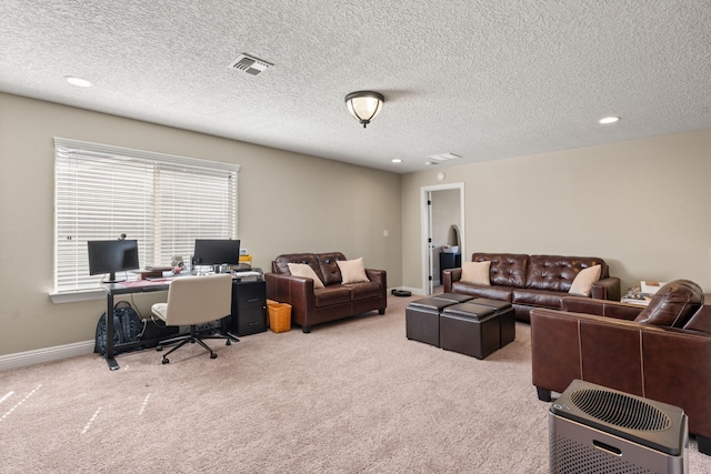 carpeted living area featuring baseboards, visible vents, and a textured ceiling