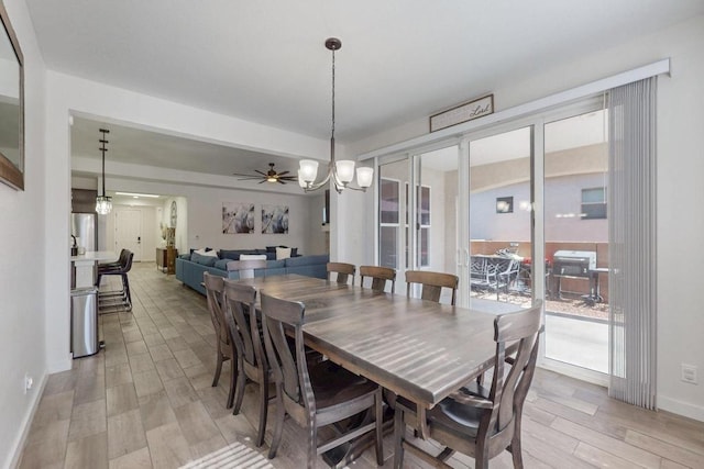 dining space featuring light wood-style floors, baseboards, and ceiling fan with notable chandelier