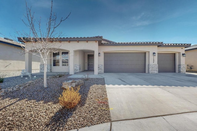 mediterranean / spanish home featuring a garage, stone siding, concrete driveway, and stucco siding