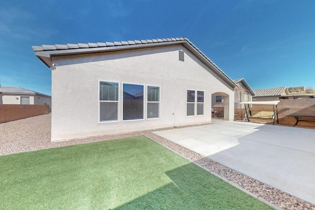 back of property with fence, a patio, and stucco siding