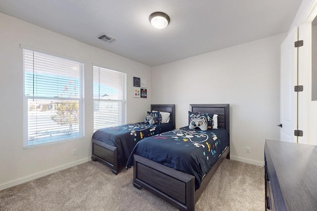 bedroom featuring baseboards, visible vents, and light colored carpet