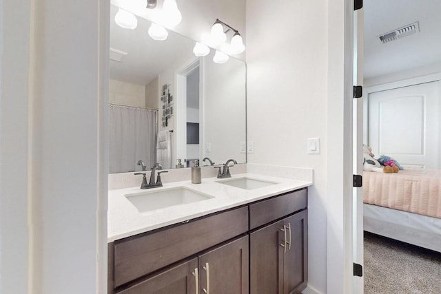 full bath featuring double vanity, visible vents, a sink, and ensuite bathroom