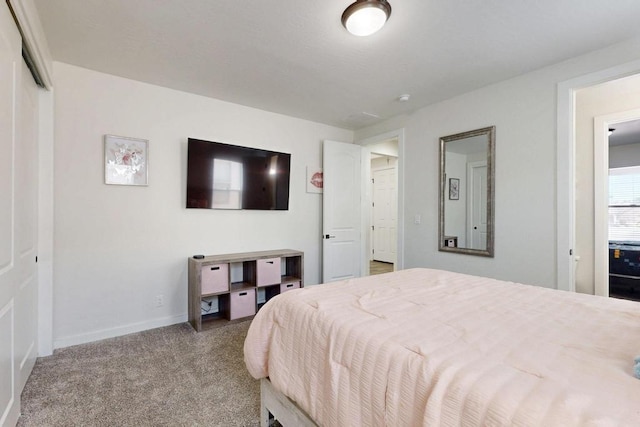 bedroom with baseboards and light colored carpet