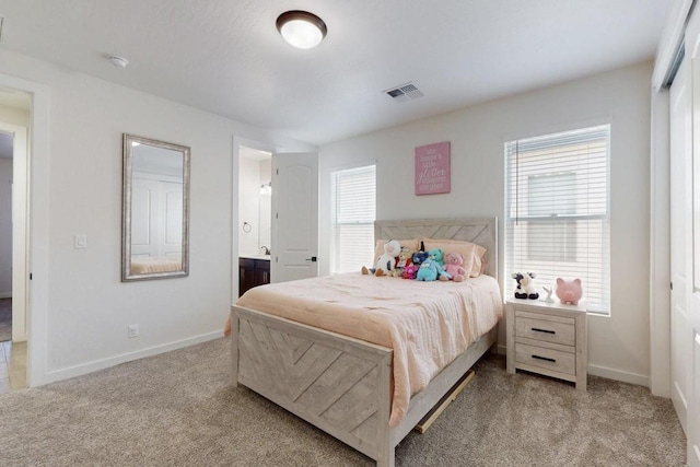 bedroom featuring light carpet, visible vents, baseboards, and ensuite bathroom