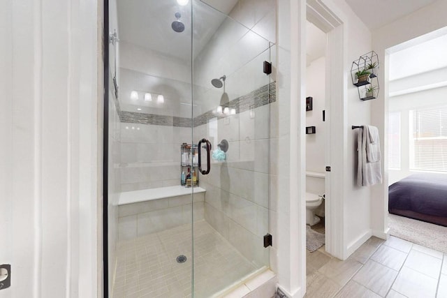 full bath with tile patterned flooring, toilet, baseboards, a shower stall, and ensuite bath