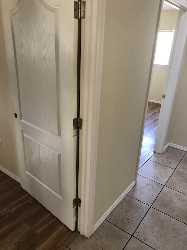 corridor featuring baseboards and tile patterned floors