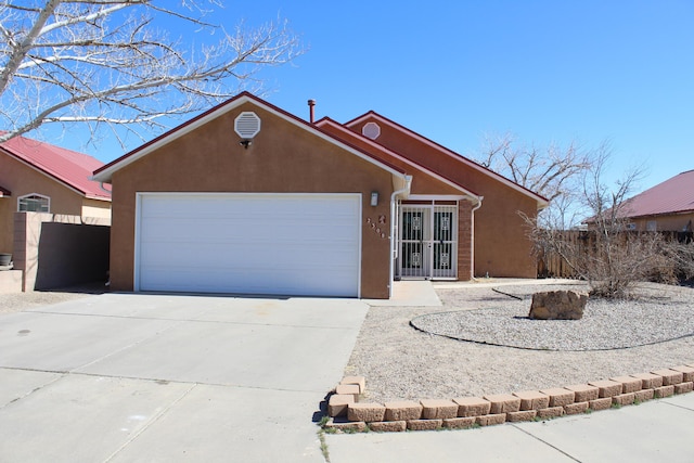 single story home with driveway, an attached garage, and stucco siding