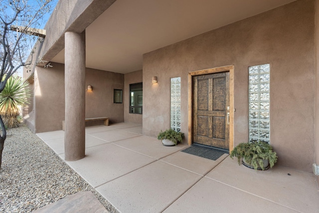 entrance to property with a patio and stucco siding