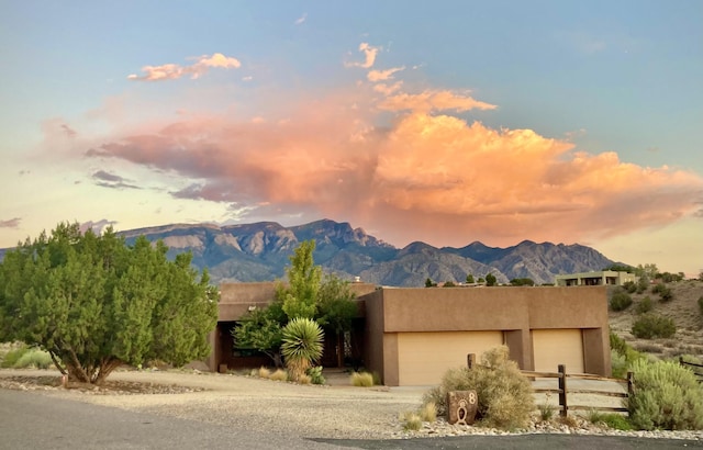 view of front of home featuring a mountain view, an attached garage, and stucco siding