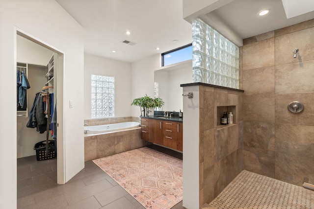 full bathroom with tile patterned flooring, visible vents, a spacious closet, a bath, and walk in shower