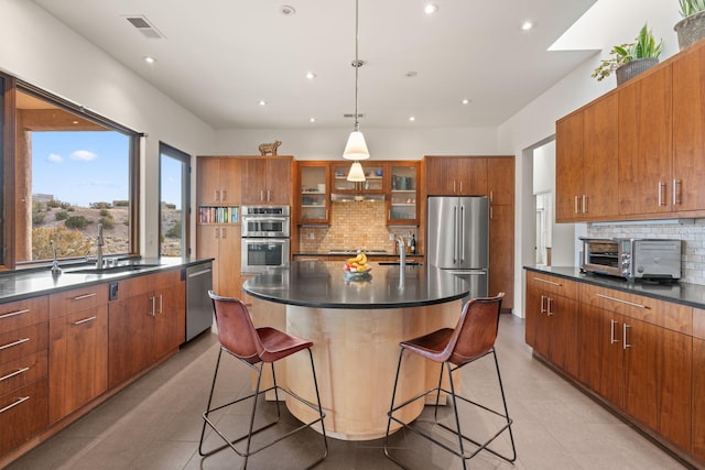 kitchen with stainless steel appliances, dark countertops, and a large island