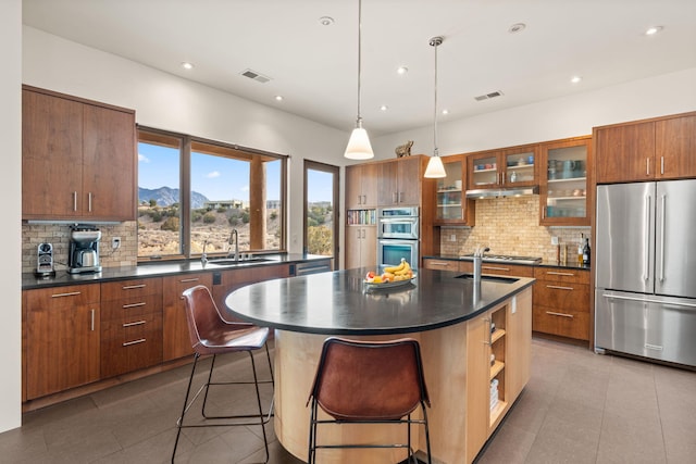 kitchen with dark countertops, appliances with stainless steel finishes, a mountain view, and hanging light fixtures