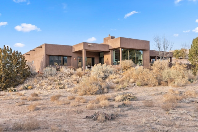 view of front of house featuring a chimney and stucco siding