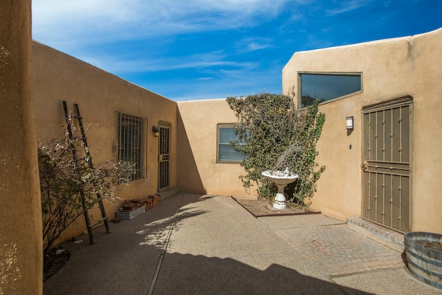 entrance to property with a patio and stucco siding