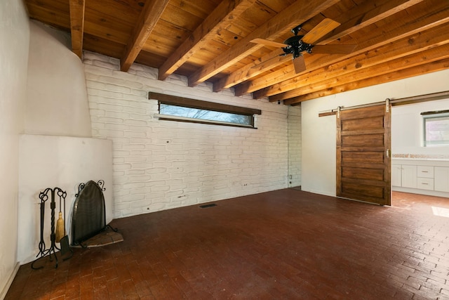 interior space featuring a barn door, wooden ceiling, brick wall, brick floor, and beam ceiling