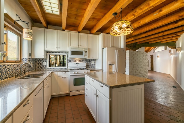 kitchen featuring white appliances, tasteful backsplash, decorative light fixtures, a sink, and beam ceiling