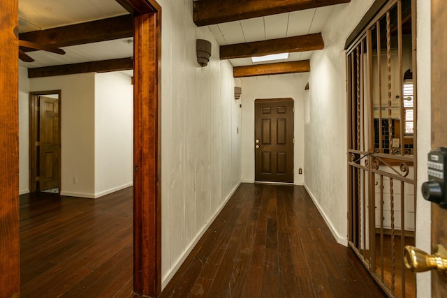 hallway featuring hardwood / wood-style flooring, baseboards, and beamed ceiling