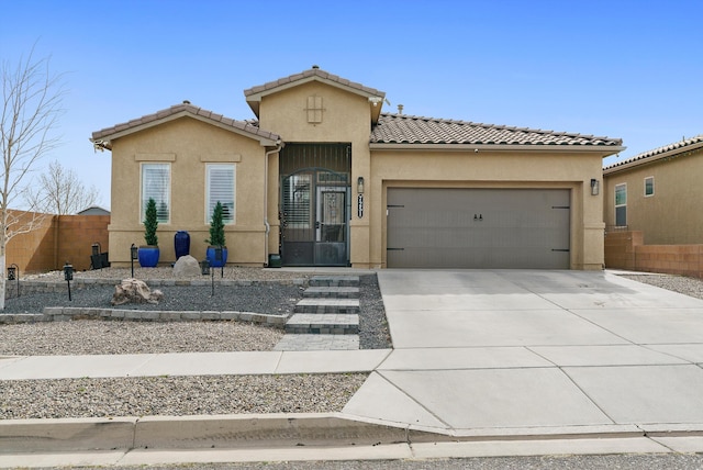 mediterranean / spanish house with driveway, a garage, a tile roof, fence, and stucco siding