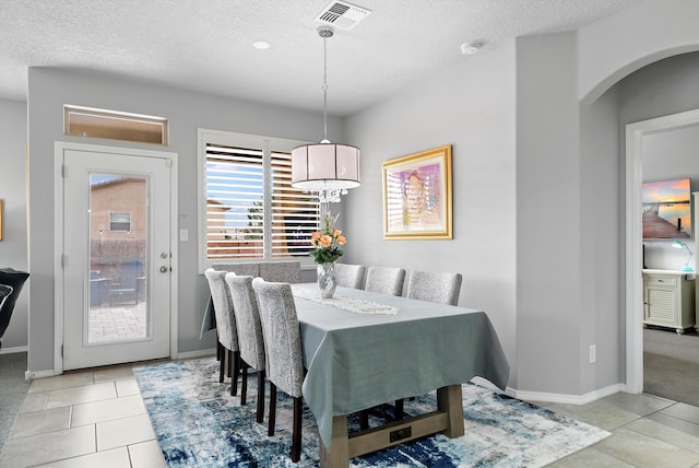 dining room featuring light tile patterned floors, a textured ceiling, and visible vents