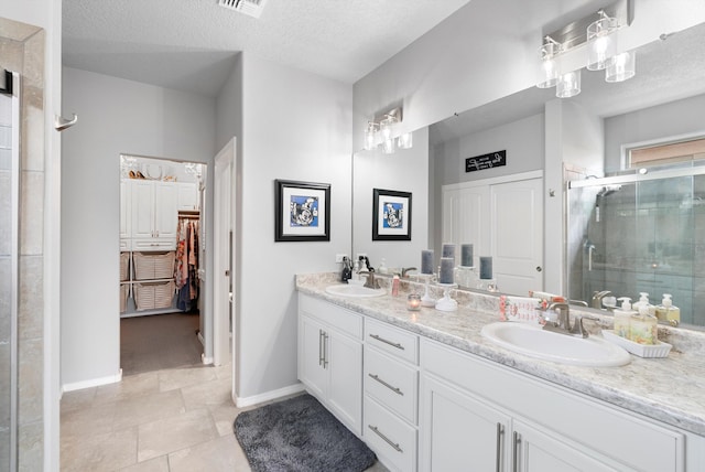 full bath featuring a shower stall, a textured ceiling, and a sink