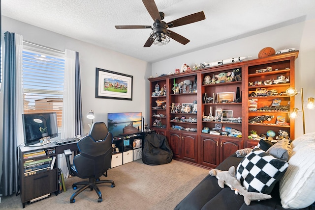 home office with a textured ceiling, ceiling fan, and carpet flooring