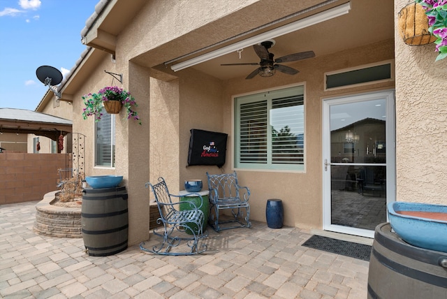 view of patio featuring ceiling fan and fence