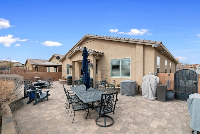 view of patio / terrace featuring outdoor dining space, fence, a gate, and central air condition unit