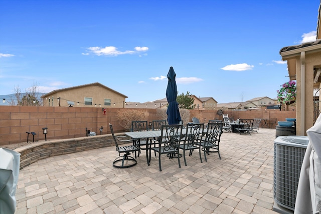 view of patio / terrace with central air condition unit, a fenced backyard, and outdoor dining space