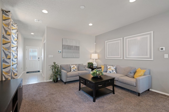 living area featuring light carpet, baseboards, a textured ceiling, and recessed lighting