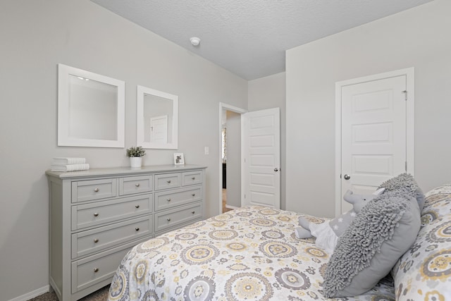 bedroom featuring a textured ceiling and baseboards