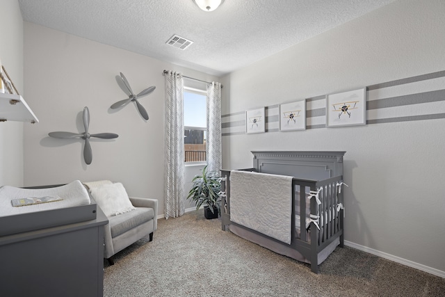 carpeted bedroom with visible vents, a textured ceiling, and baseboards