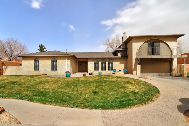 view of front of property with a balcony, a garage, brick siding, concrete driveway, and a front yard