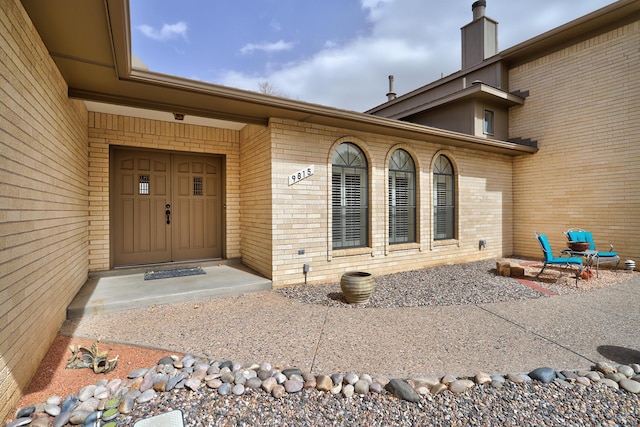 doorway to property with brick siding