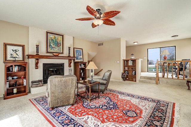 carpeted living room featuring a ceiling fan, visible vents, and a fireplace