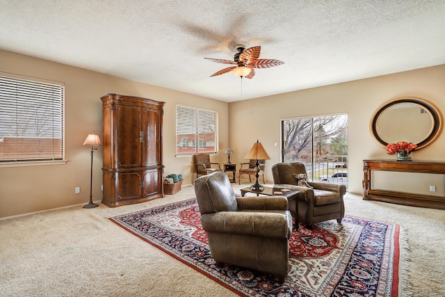 living room featuring ceiling fan, a textured ceiling, and carpet flooring