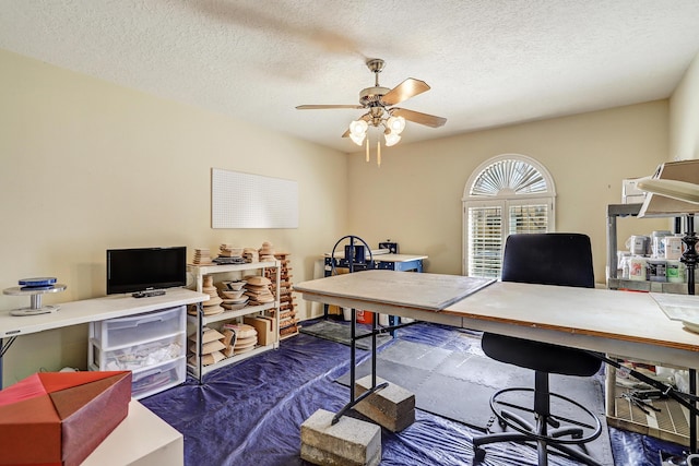 home office featuring ceiling fan, dark colored carpet, and a textured ceiling