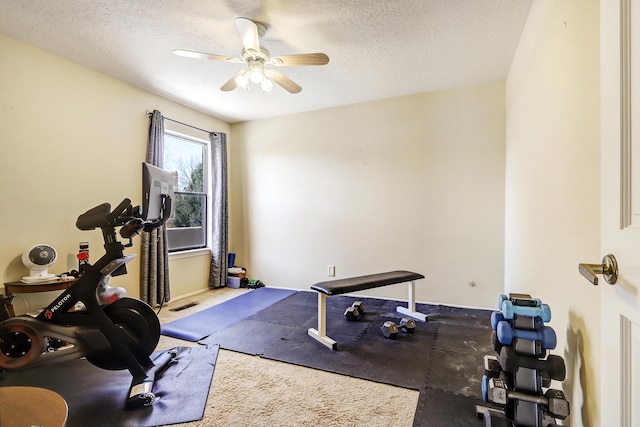 workout room featuring ceiling fan and a textured ceiling