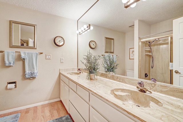 bathroom featuring toilet, a textured ceiling, a sink, and wood finished floors