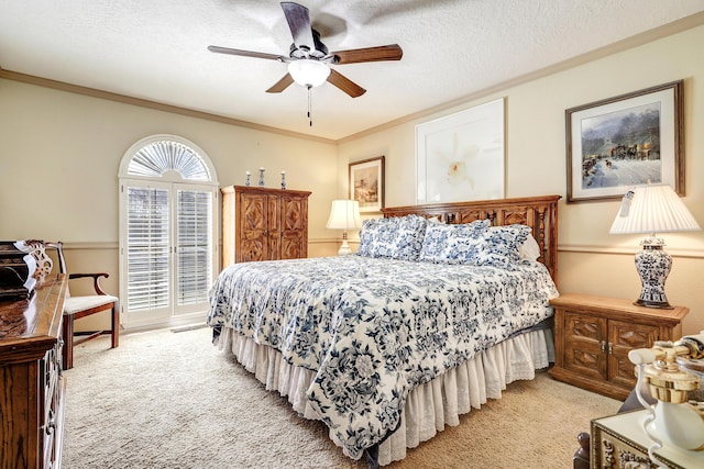 bedroom featuring a ceiling fan, light colored carpet, crown molding, and a textured ceiling